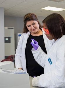 “REAL-LIFE EXPERIENCE” Sandra Chimon-Peszek Rogers, Ph.D., director of the Calumet College of St. Joseph Biophysical Chemistry Department and a researcher into Alzheimer’s disease, works with biomedical major Ciara Carmichael.